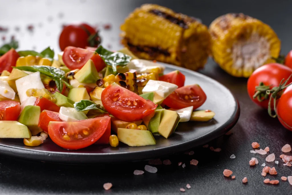 Fresh Summer Corn Salad with tomatoes, avocado, red onion, cilantro, and lime dressing.