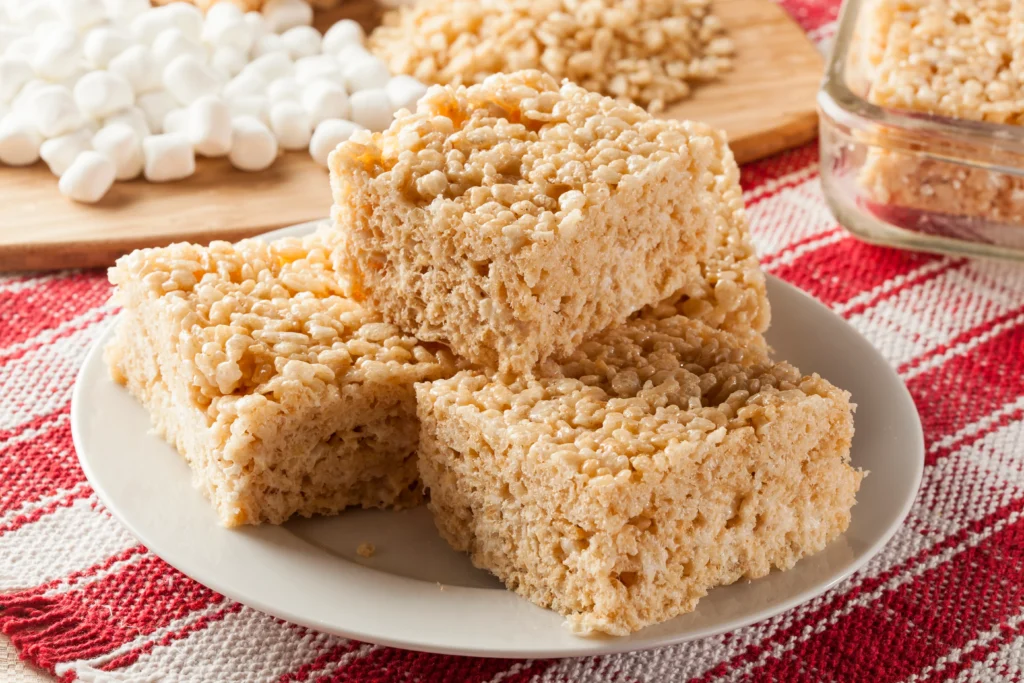 High-Protein Rice Krispie Treats stacked on a plate with a chewy, crispy texture.