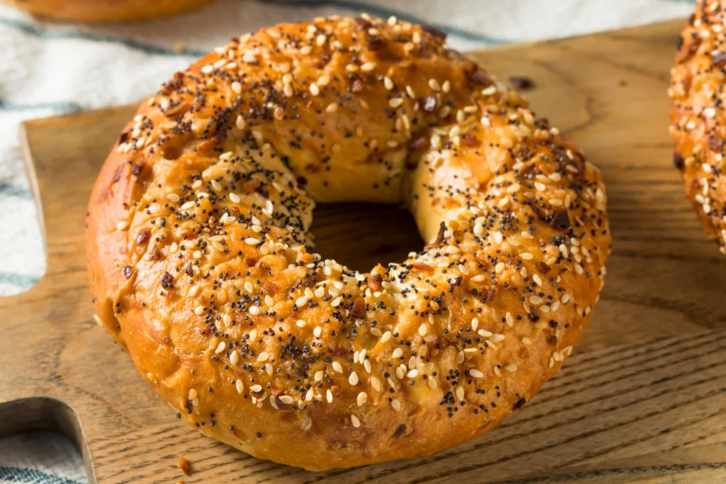 Freshly baked homemade bagels cooling on a wire rack with a golden-brown crust, highlighting the perfect texture and shape while illustrating common mistakes that can affect flavor and appearance.