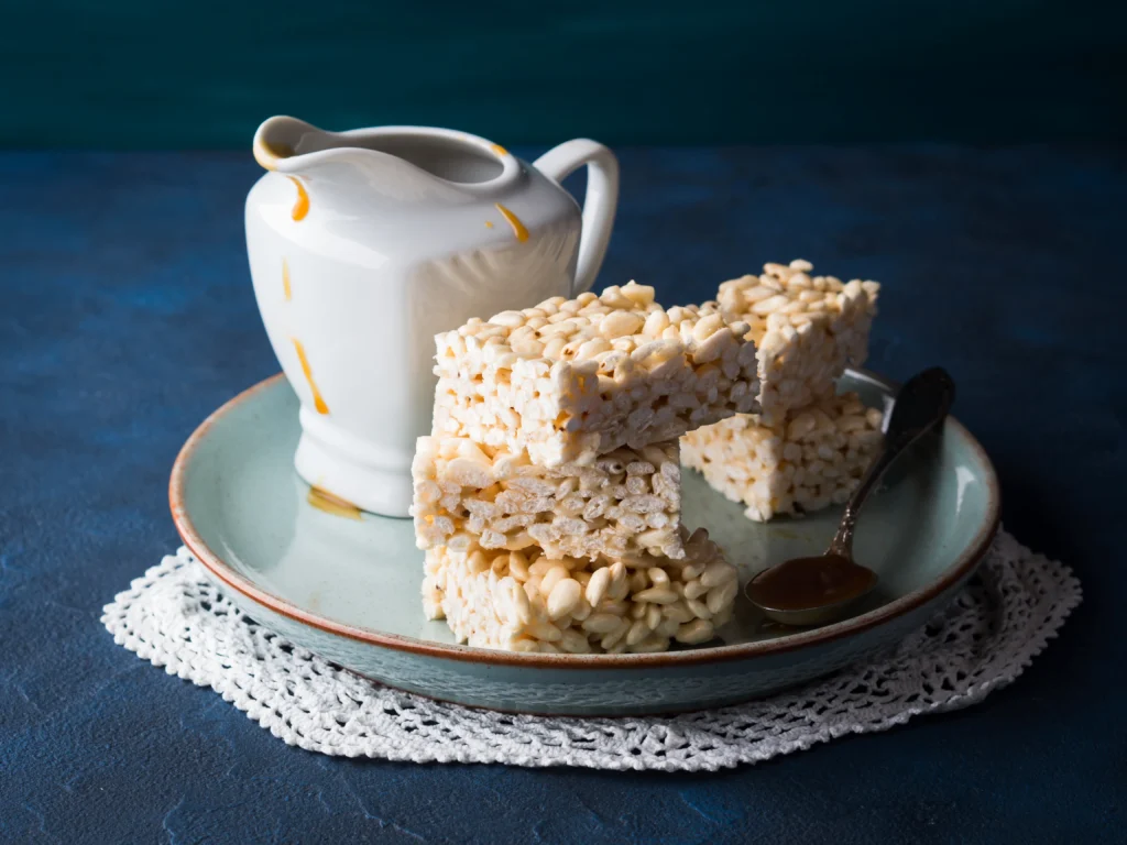 High-Protein Rice Krispie Treats stacked on a plate with a chewy, crispy texture.