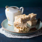 High-Protein Rice Krispie Treats stacked on a plate with a chewy, crispy texture.