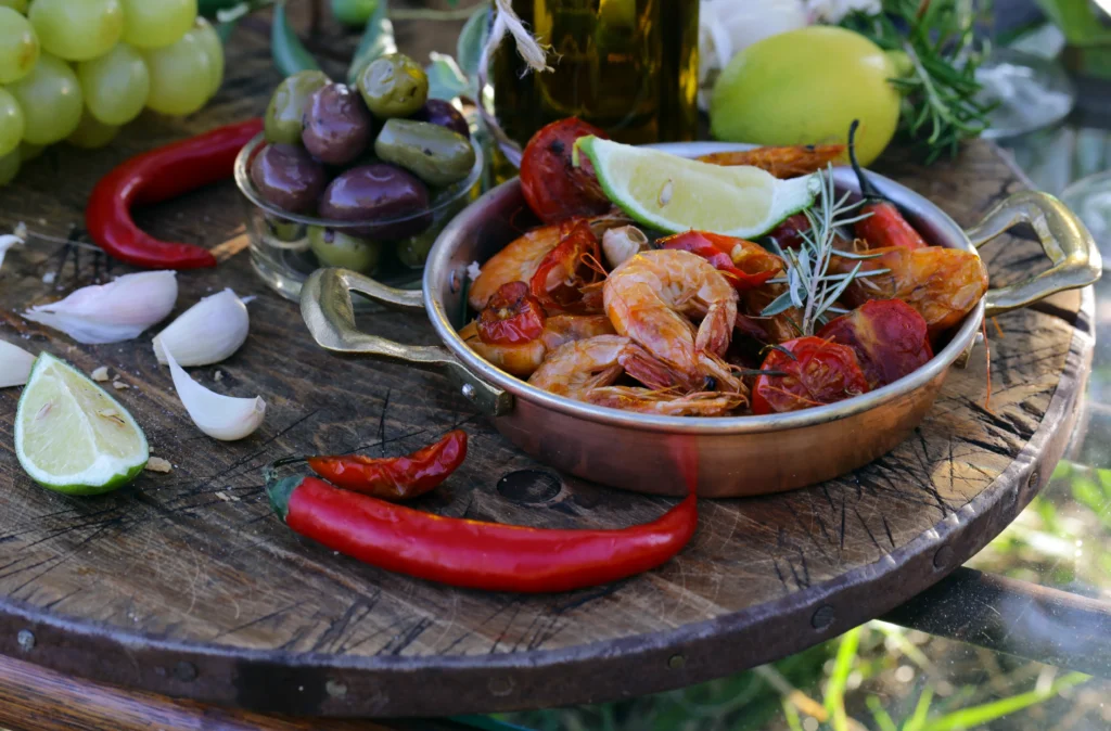 Smoky shrimp with sliced chorizo cooked in a rich paprika-infused sauce, garnished with fresh parsley and served in a rustic skillet with lemon wedges.