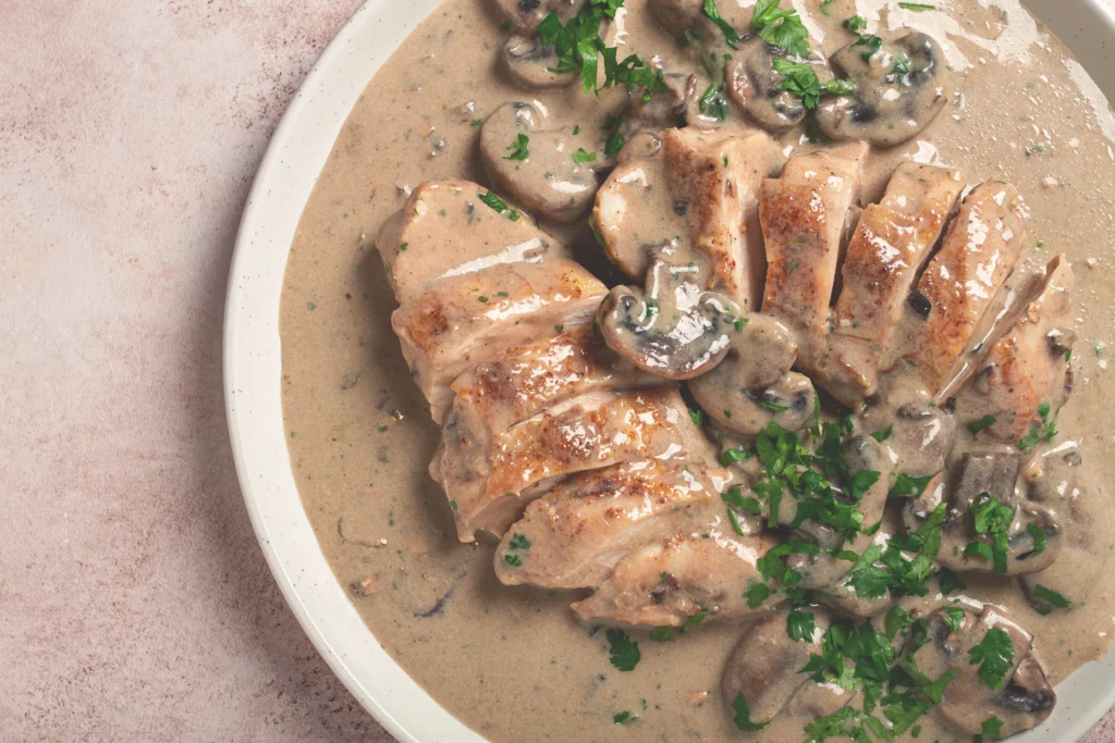 Easy Creamy Tuscan Chicken with tender chicken breasts in garlic Parmesan cream sauce, spinach, and sun-dried tomatoes served in a skillet