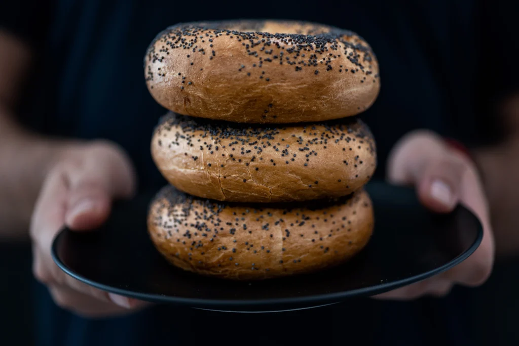 Freshly baked homemade bagels cooling on a wire rack with a golden-brown crust, highlighting the perfect texture and shape while illustrating common mistakes that can affect flavor and appearance.