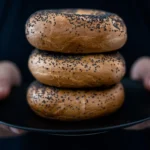 Freshly baked homemade bagels cooling on a wire rack with a golden-brown crust, highlighting the perfect texture and shape while illustrating common mistakes that can affect flavor and appearance.