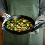 Sausage and Brussels sprouts stir-fry with caramelized vegetables in a skillet
