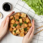 Crispy tofu with creamy peanut sauce served with rice and vegetables