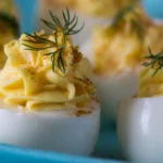 Easy classic deviled eggs topped with paprika, an affordable family-friendly appetizer under $5.
