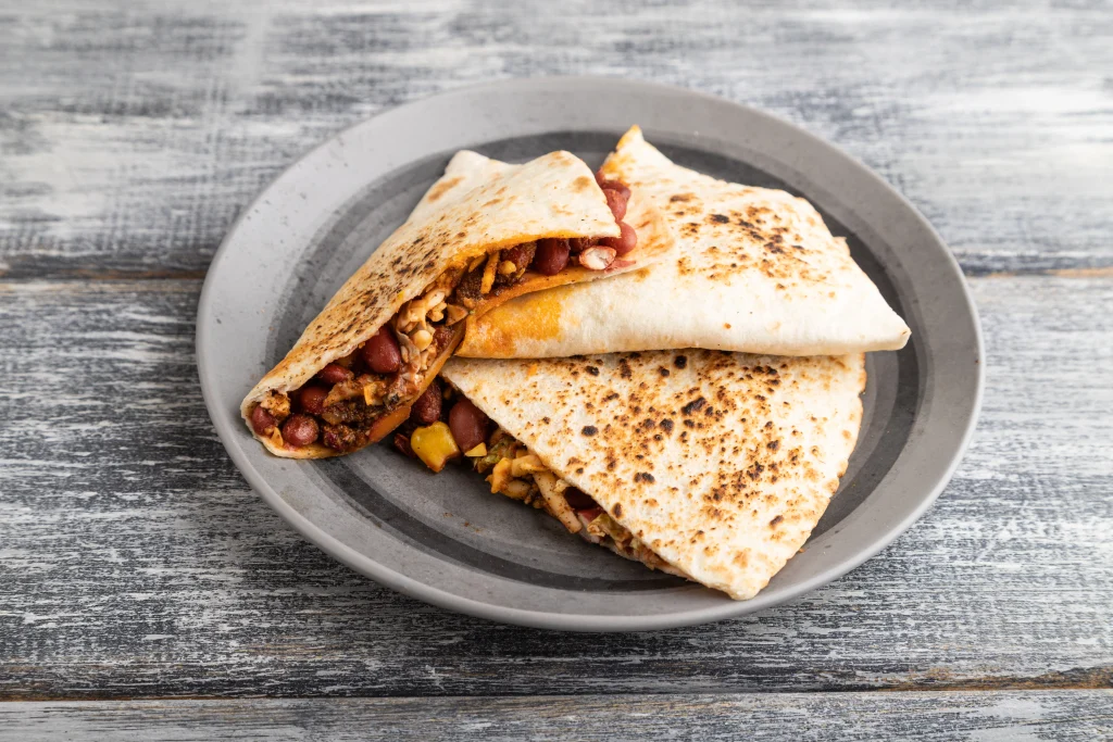 Cheesy black bean quesadilla triangles with melted cheese in crispy golden tortillas