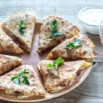 heesy black bean quesadilla triangles with melted cheese in crispy golden tortillas